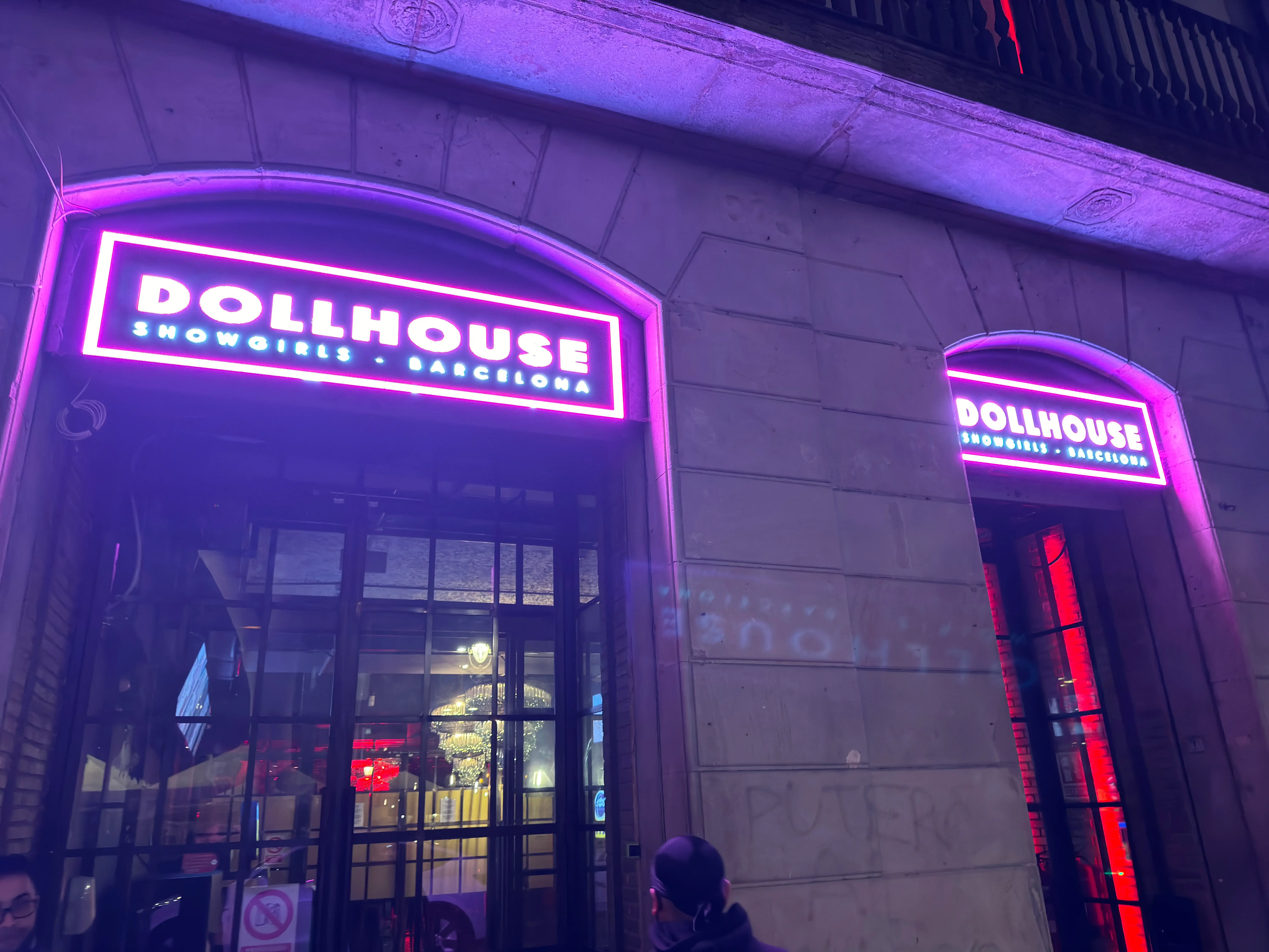 Neon-lit entrance of Dollhouse Showgirls in Barcelona at night